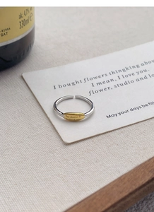 Detail of S925 silver open ring with gold oval plate and engraved inspirational quote