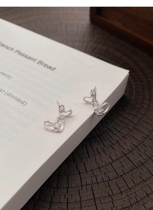 Detail of S999 silver double heart stud earrings with irregular texture and cubic zirconia