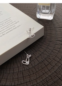 Macro detail of S999 silver heart stud earrings with hammered texture and crystal stone
