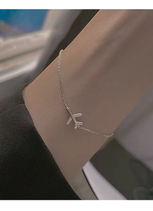 Macro shot of silver airplane pendant bracelet with sparkling zircon stones on women wrist