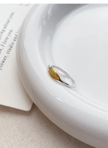 Macro shot of silver ring with engraved golden plate saying You deserve to be loved