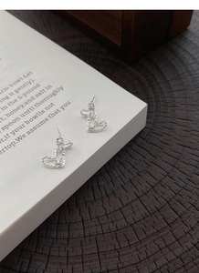 Detailed view of S999 sterling silver heart earrings with hammered texture and small zircon