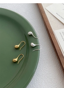 Dettaglio di orecchini a goccia in argento S925 in finiture lucide oro e argento