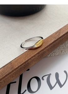 Detailed macro view of S925 sterling silver two-tone adjustable ring with letter engraving