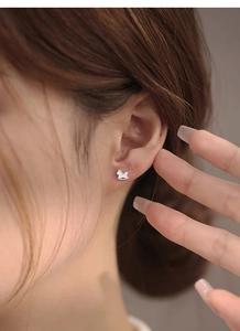 Macro shot of S999 sterling silver rocking horse stud earring worn on the ear