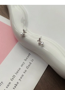 Detail of S999 sterling silver cherry pearl earrings with zircon on a ceramic stand