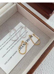 Detail view of gold and silver S925 sterling silver earrings with textured grainy finish