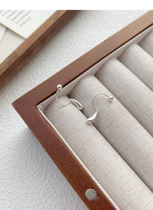 Detail view of S999 sterling silver teardrop earrings with screw backs in a wooden box