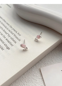 Makroaufnahme von Tulpen-Ohrsteckern mit rosa Emaille und Zirkon-Detail auf dem Blatt