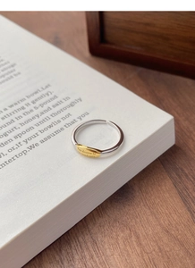 Detail of S925 silver adjustable ring with gold inspirational engraving plate on a book