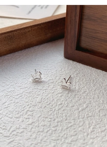 Close-up of S999 sterling silver rocking horse stud earrings with polished finish