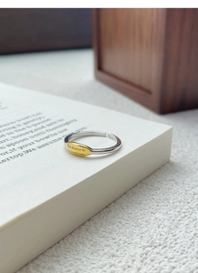 Close-up of S925 silver adjustable ring with engraved inspirational quote on a book