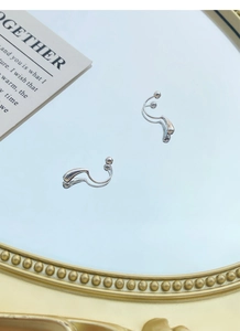 Macro view of S999 silver water drop earrings with screw back on a vintage mirror