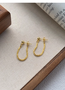 Close-up of golden S925 sterling silver ball stud earrings with a textured chain drop