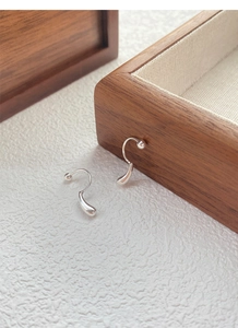 Macro detail of S999 silver teardrop earrings with minimalist screw back hook design
