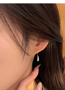 Macro detail of minimalist S999 sterling silver teardrop earrings with mirror finish
