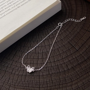 Bracciale minimalista a farfalla in argento S999 con chiusura a moschettone su legno scuro