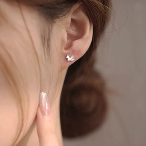 Minimalist S999 sterling silver rocking horse stud earring worn on model's ear