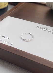 Close-up of S999 silver fish ring with zircon detail on a minimalist display stand