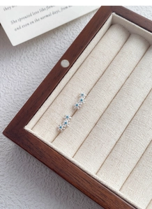 Vue détaillée des boucles d'oreilles fleurs en argent S999 avec zircons bleus et coffret