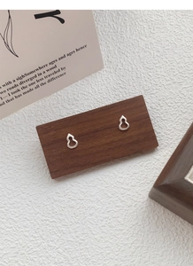 Détail de boucles d'oreilles gourde en argent S999 avec texture perlée sur socle