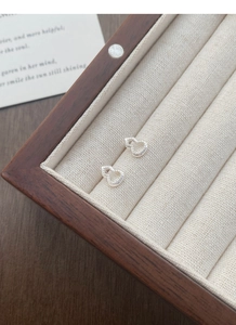Vue détaillée des boucles d'oreilles en argent ajouré en forme de gourde avec texture