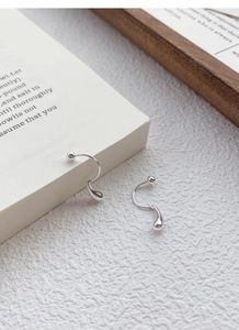 Detailed close-up of S999 sterling silver teardrop earrings with a spiral screw-back design