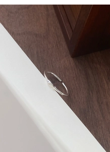 Detailed view of the minimalist S999 sterling silver fish ring with a sparkling gemstone eye