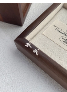 Macro shot of minimalist dragonfly stud earrings in polished S999 sterling silver