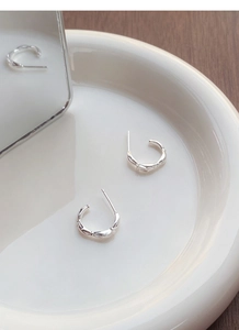 Detailed macro view of silver hoop earrings featuring a unique bamboo texture design