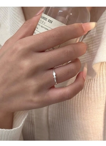 Detail of a minimalist S999 silver fish ring on finger with elegant aesthetic style