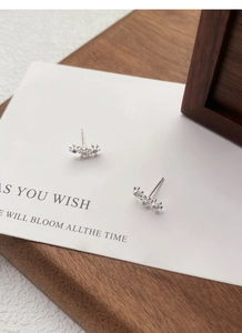 Détail macro de boucles d'oreilles fleurs en argent avec petites pierres bleues
