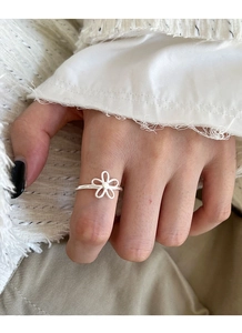 Detail of S925 sterling silver hollow flower open ring worn on a finger