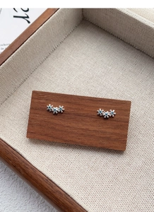 Détail des boucles d'oreilles fleurs en argent S999 avec strass bleus étincelants