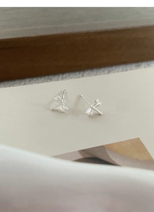 Detailed close-up of S999 sterling silver dragonfly stud earrings on a display card