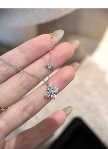 Detail of silver clover pendant necklace featuring pavé set sparkling cubic zirconia stones