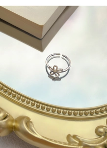 Macro shot of S925 sterling silver hollow flower ring on a vintage mirror surface