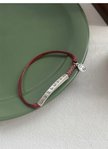 Macro view of S999 silver red string bracelet with Ping An blessing charm