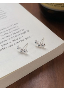 Détail macro de boucles d'oreilles en argent S999 avec trois fleurs et pierres bleues