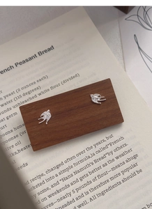 Close-up of S999 sterling silver swallow stud earrings with detailed feather texture