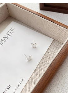 Vue rapprochée de boucles d'oreilles papillon en argent avec des ailes finement gravées