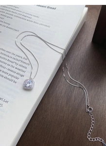 Detail of square halo zircon pendant on a fine silver box chain with adjustable clasp