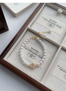 Detail of S925 silver pearl bracelet with pink gemstone centerpiece and adjustable gold clasp