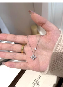 Macro shot of silver four-leaf clover pendant necklace with cubic zirconia inlay details
