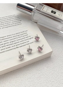 Détail macro de boucles d'oreilles cœur en argent S999 avec accents étoilés