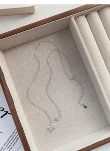 Macro shot of S925 sterling silver four-leaf clover necklace with pavé zircon stones