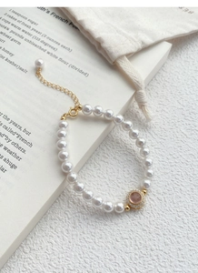 Macro shot of S925 silver pearl bracelet with pink gemstone and cubic zirconia details
