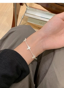 Gros plan d'un bracelet papillon en argent sterling S925 avec breloques texturées