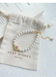 Detail of S925 silver pearl bracelet with pink cat eye stone and branded gift pouch