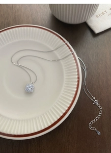Close-up of S999 silver necklace with square sugar zircon pendant on white ceramic plate